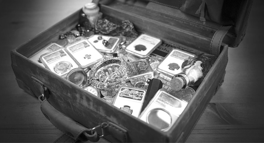 Open treasure case: dragon bracelet, pocket watch, slabbed coins, corked bottle